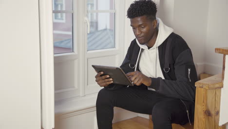 Retrato-De-Un-Hombre-Serio-Sentado-En-Casa-Usando-Una-Tableta-Digital